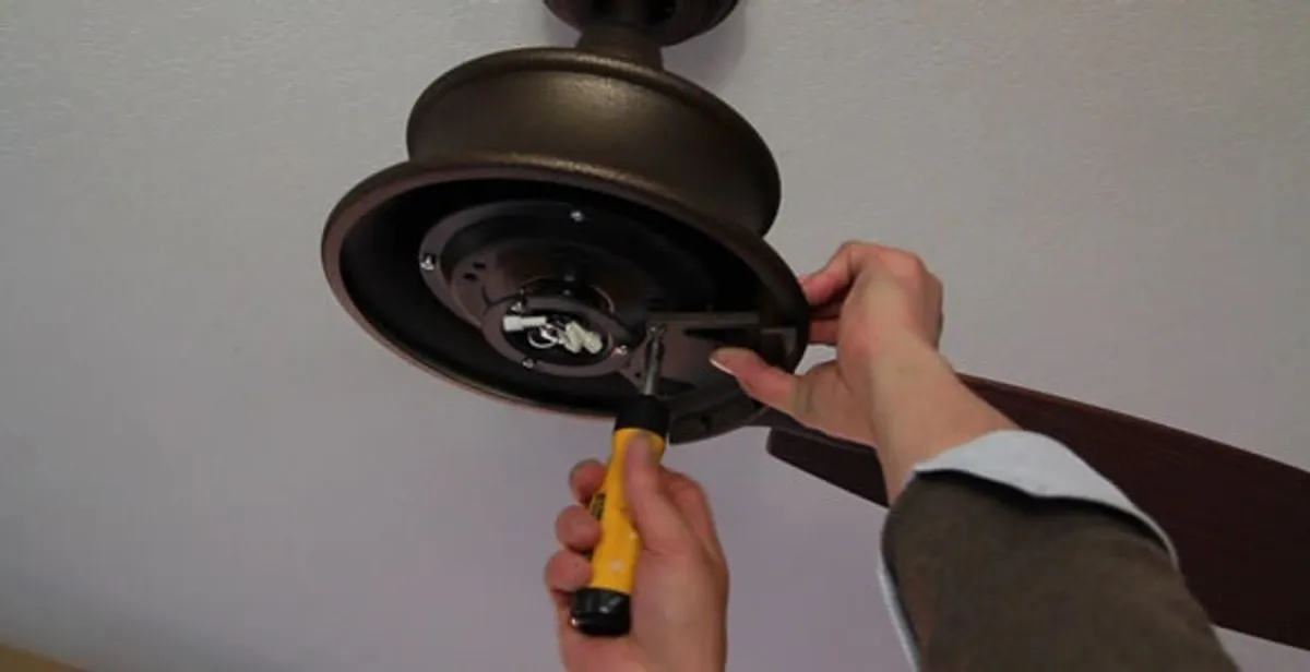 Electrician installing ceiling fan mounting bracket and fixture in Orlando, FL