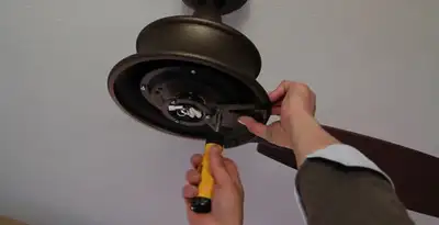 Electrician installing ceiling fan mounting bracket and fixture in Orlando, FL