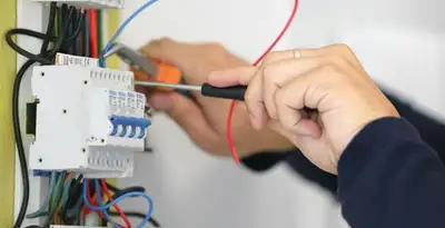 Electrician installing and adjusting circuit breakers in an electrical panel in Orlando, FL