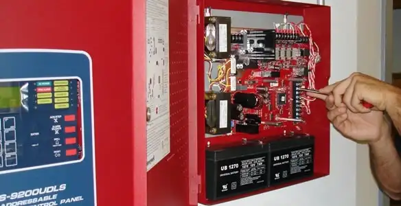 fire alarm installation service showing technician configuring fire alarm control panel in Orlando, FL