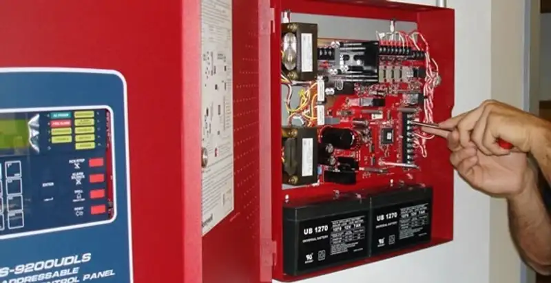 fire alarm installation service showing technician configuring fire alarm control panel in Orlando, FL