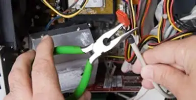 Licensed electrical contractor performing electrical repair with tools in Ocoee, FL