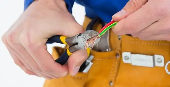 licensed electrician securing electrical wiring with professional tools during service work in Orlando, FL
