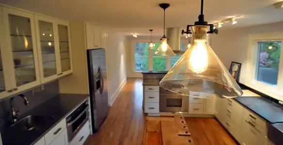 Residential electrician installing modern indoor light fixture in a home in Orlando, FL